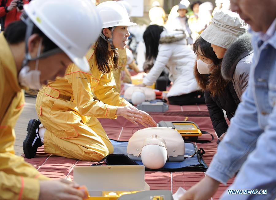 Workers show medical emergency measures during a drill in Tokyo, capital of Japan, on March 11, 2013. A drill to take precautions against natural calamities including medical emergency and fire fighting drills was held here to mark the two year anniversary of the March 11 earthquke and ensuing tsunami that left more than 19,000 people dead or missing and triggered a nuclear accident the world had never seen since 1986. (Xinhua/Kenichiro Seki)  