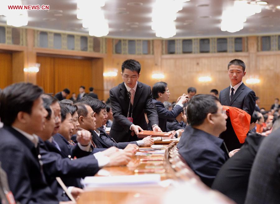 Staff members distribute ballots at the fourth plenary meeting of the first session of the 12th National Committee of the Chinese People's Political Consultative Conference (CPPCC) held at the Great Hall of the People in Beijing, capital of China, March 11, 2013. Chairman, vice-chairpersons, secretary-general and Standing Committee members of the 12th CPPCC National Committee will be elected Monday afternoon. (Xinhua/Wang Ye)