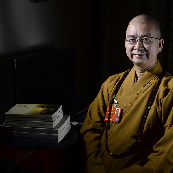 Master Xuecheng poses with his books in Beijing, on March 5, 2013. Master Xuecheng is a CPPCC National Committee member and the abbot of Longquan Temple. He dreams of establishing a university for Buddhist followers and ascetics to study Buddhism and the Buddhist culture deeply and systematically. [Photo/Xinhua]