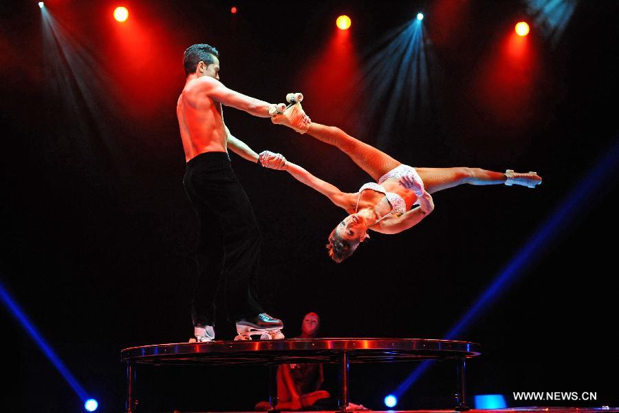 Acrobats perform during the media preview of the circus show "Le Noir" held in the Marina Bay Sands Theatre in Singapore, March 12, 2013. The show with the theme of "Black, white and red" premieres in Singapore Tuesday. (Xinhua/Then Chih Wey) 