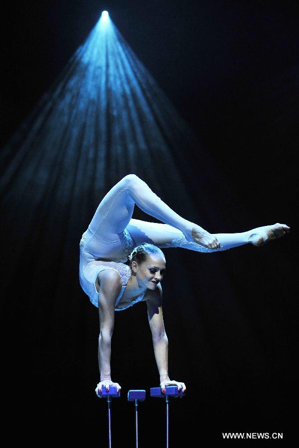 An acrobat performs during the media preview of the circus show "Le Noir" held in the Marina Bay Sands Theatre in Singapore, March 12, 2013. The show with the theme of "Black, white and red" premieres in Singapore Tuesday. (Xinhua/Then Chih Wey) 