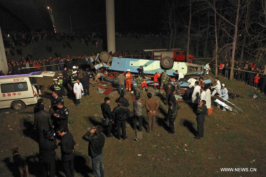 Rescuers conduct a rescue operation at the accident site after a sleeper coach fell off the Jingzhou Yangtze River Bridge in Jingzhou, central China's Hubei Province, March 12, 2013. At least 14 people were killed and nine injured during the the accident which happened at around 7:00 p.m. Tuesday when a flat tire caused the coach to break through the guardrail at the southern end of the bridge and hit the ground underneath the structure. Rescue work is under way. (Xinhua/Shi Jiuyong)  