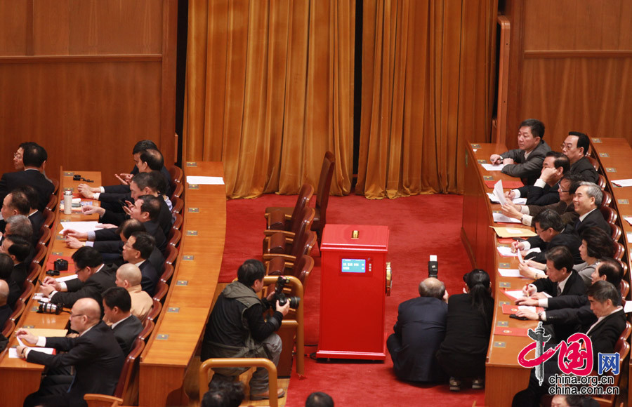 Photographers squat down to wait at the 4th plenary meeting of the first session of the 12th National Committee of the Chinese People's Political Consultative Conference (CPPCC) held in the Great Hall of the People in Beijing, capital of China, March 11, 2013. Chairman, vice-chairpersons, secretary-general and members of standing committee of the 12th CPPCC National Committee were elected here on Monday afternoon. (Xinhua/Wang Ye)