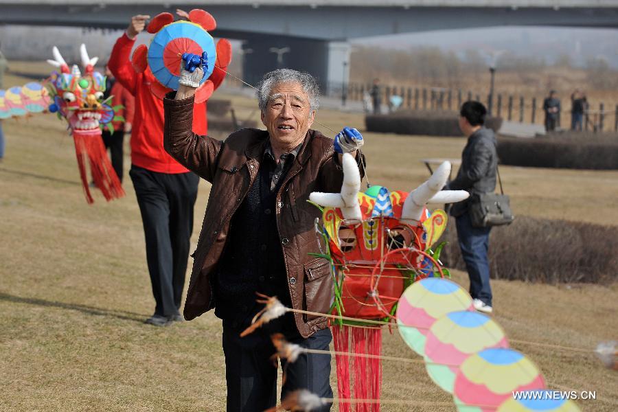 Kite lover flies a kite at the Fenhe Park during a competition in Taiyuan, capital of north China's Shanxi Province, March 13, 2013. (Xinhua/Zhan Yan)