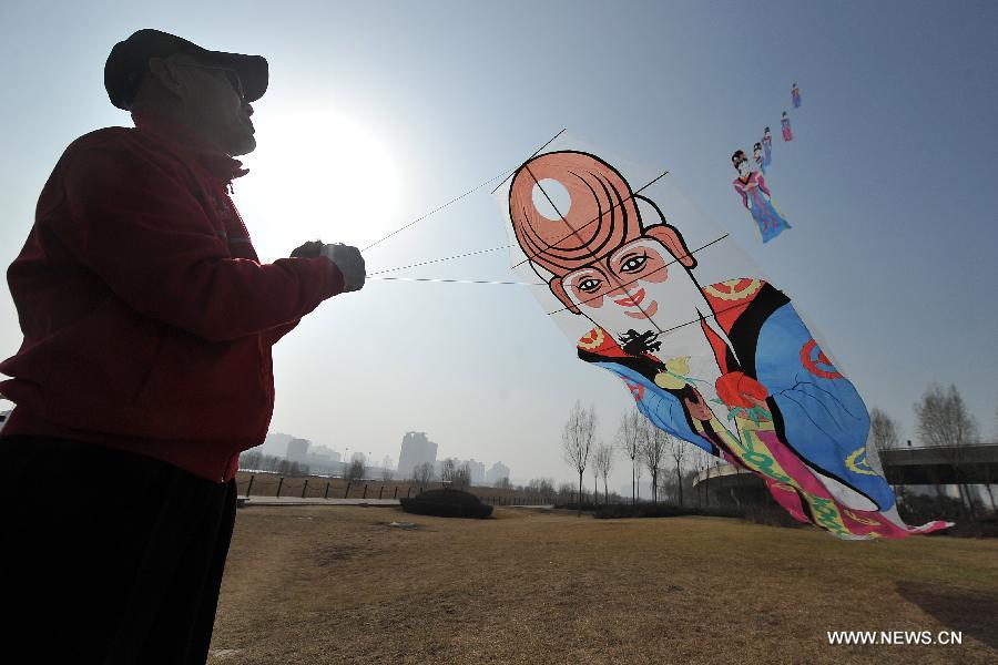 Kite lover flies a kite at the Fenhe Park during a competition in Taiyuan, capital of north China's Shanxi Province, March 13, 2013. (Xinhua/Zhan Yan)