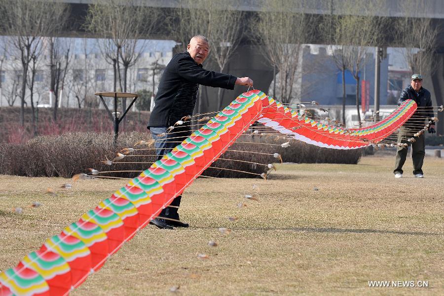 Kite lover flies a kite at the Fenhe Park during a competition in Taiyuan, capital of north China's Shanxi Province, March 13, 2013. (Xinhua/Zhan Yan)