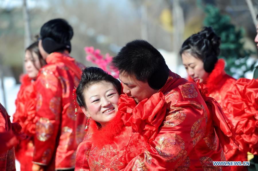 Couples attend a mass wedding ceromony in Jiayin, northeast China's Heilongjiang Province, March 13, 2013. Fifty-five pairs of couples, including ten from Russia, took part in a mass wedding here on Wednesday. (Xinhua/Wang Song)