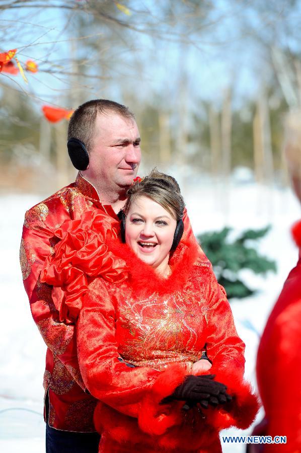 A Russian couple attend a mass wedding ceromony in Jiayin, northeast China's Heilongjiang Province, March 13, 2013. Fifty-five pairs of couples, including ten from Russia, took part in a mass wedding here on Wednesday. (Xinhua/Wang Song)