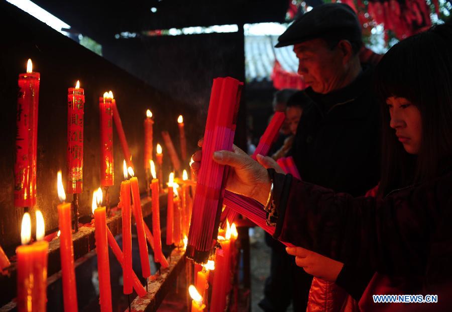 People burn incense at a temple fair for blessings to celebrate "Er Yue Er" in Wushan Township of Changfeng County, east China's Anhui Province, March 13, 2013, on the occasion of the second day of the second lunar month, known in Chinese as Er Yue Er, "a time for the dragon to raise its head", as a Chinese saying goes. Local residents celebrated the festival with traditional performance to commemorate the King of Wu kingdom and pray for a good harvest in the coming year. (Xinhua/Yu Junjie) 