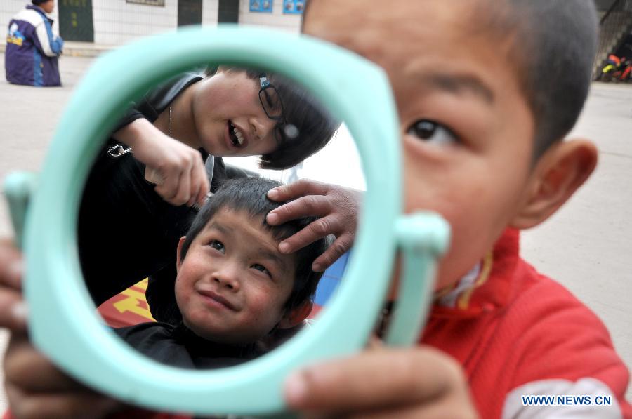 A boy has his haircut at a welfare center in Handan City, north China's Hebei Province, March 13, 2013, on the occasion of the second day of the second lunar month, known in Chinese as Er Yue Er, "a time for the dragon to raise its head", as a Chinese saying goes. Barbershops across the country opened early to begin one of their busiest days of the year, as many Chinese hold the superstitious belief that getting a haircut at a time when the "dragon raises its head" means they will have a vigorous start to the new year. (Xinhua/Hao Qunying)