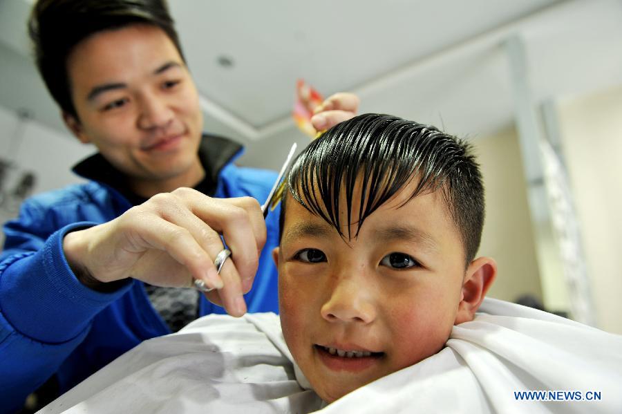 A boy has his hair cut at a barbershop in Suining County of Xuzhou City, east China's Jiangsu Province, March 13, 2013, on the occasion of the second day of the second lunar month, known in Chinese as Er Yue Er, "a time for the dragon to raise its head", as a Chinese saying goes. Barbershops across the country opened early to begin one of their busiest days of the year, as many Chinese hold the superstitious belief that getting a haircut at a time when the "dragon raises its head" means they will have a vigorous start to the new year. (Xinhua/Hong Xing)