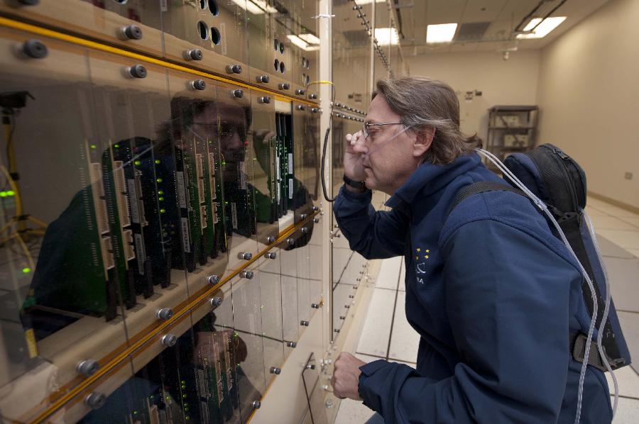 Image provided by the European Southern Observatory (ESO) on March 12, 2013, shows a correlator worker, Enrique Garcia, examining one of world's most powerful supercomputers. Atacama Large Millimetre/Submillimetre Array (ALMA) project is an international astronomical facility located 5,000 meters above Andes' El Llano de Chajnantor's plateau, some 50 km of San Pedro de Atacama in Chile's Second Region, in Antofagasta. The ALMA, an international partnership project between Europe, Japan and the United States, with the cooperation of Chile, is presently the largest astronomical project in the world and it will be inaugurated in Chile on March 13, 2013 to celebrate his transformation from a construction project to an observatory. (Xinhua/ESO)