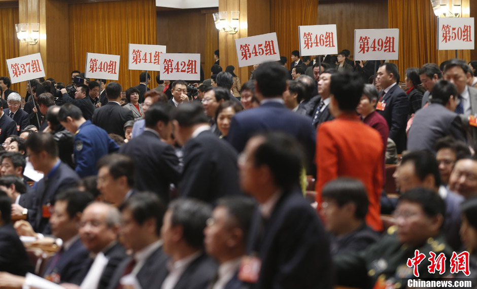 On March 12, the 12th National Committee of the Chinese People's Political Consultative Conference concluded its first session. The staff members rise placards to show the CPPCC members the way out. (Chinanews.com/ Sheng Jiapeng)