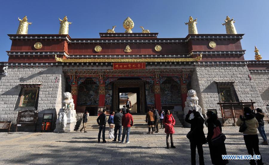Tourists visit the Ganden Stumtseling Monastery, the largest Tibetan Buddhism temple in Yunnan Province, in Shangri-la County, southwest China's Yunnan Province, March 14, 2013. (Xinhua/Lin Yiguang) 