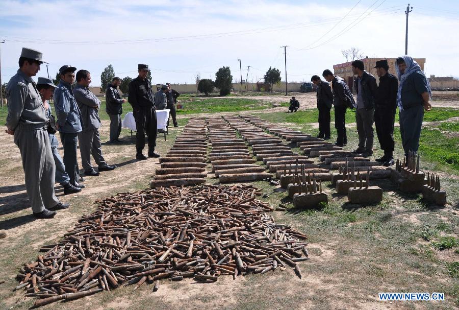 Afghan policemen stand near the weapon cache in Jawzjan Province in northern Afghanistan, March 14, 2013. Afghan security forces found a Taliban weapon cache during an operation in Jawzjan on Thursday, police officials said. (Xinhua/Arui) 