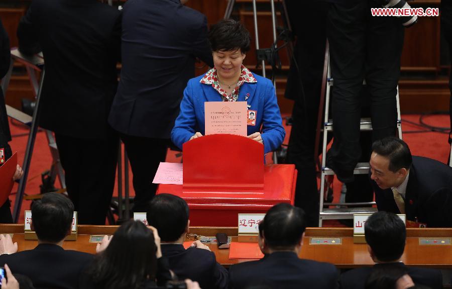 A deputy casts her vote at the fifth plenary meeting of the first session of the 12th National People's Congress (NPC) at the Great Hall of the People in Beijing, capital of China, March 15, 2013. The meeting will vote to decide on the premier, as well as vice chairpersons and members of the Central Military Commission of the People's Republic of China. President of the Supreme People's Court and procurator-general of the Supreme People's Procuratorate will also be elected. (Xinhua/Jin Liwang)