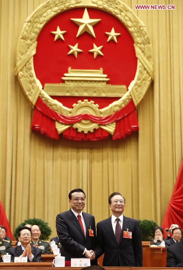 Wen Jiabao (R) shakes hands with Li Keqiang at the fifth plenary meeting of the first session of the 12th National People's Congress (NPC) at the Great Hall of the People in Beijing, capital of China, March 15, 2013. Li Keqiang was endorsed as the premier of China's State Council at the meeting here on Friday. (Xinhua/Ju Peng)