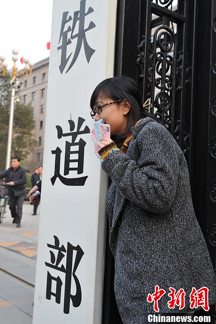 Nostalgic residents line up outside the headquarters of the Ministry of Railway to take photos with its sign yesterday afternoon. On the day, the first session of the 12th NPC endorsed the government restructuring plan, according to which the Ministry of Railway would be dissolved.（Photo/Chinanews.com）