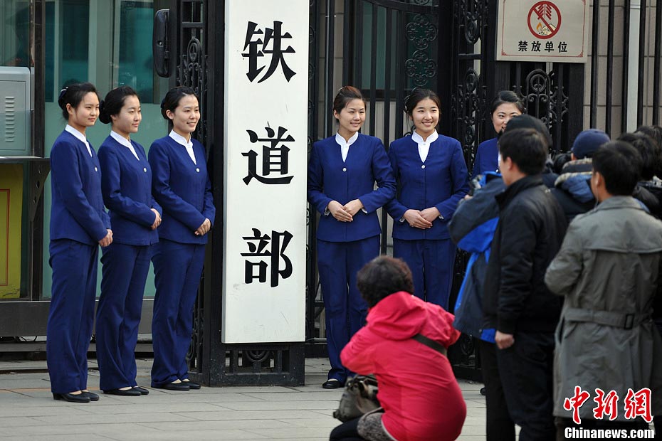 Nostalgic residents line up outside the headquarters of the Ministry of Railway to take photos with its sign yesterday afternoon. On the day, the first session of the 12th NPC endorsed the government restructuring plan, according to which the Ministry of Railway would be dissolved.（Photo/Chinanews.com）