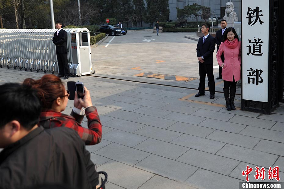 Nostalgic residents line up outside the headquarters of the Ministry of Railway to take photos with its sign yesterday afternoon. On the day, the first session of the 12th NPC endorsed the government restructuring plan, according to which the Ministry of Railway would be dissolved.（Photo/Chinanews.com）