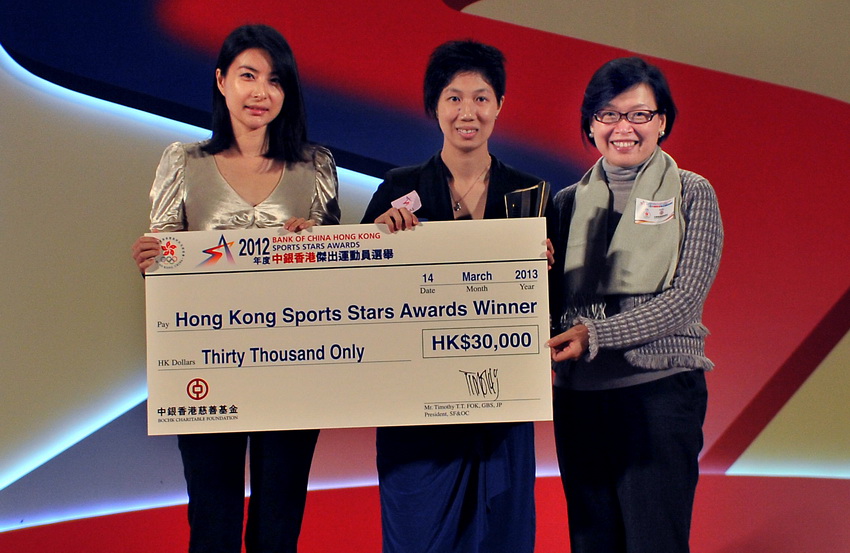 Former Chinese diving queen Guo Jingjing (L) awards the "Hong Kong Sports Stars" to intellectually disabled table tennis player Wong Ka Man (M) at the Hong Kong Convention and Exhibition Centre on March 14, 2013. (Xinhua/Chen Xiaowei)