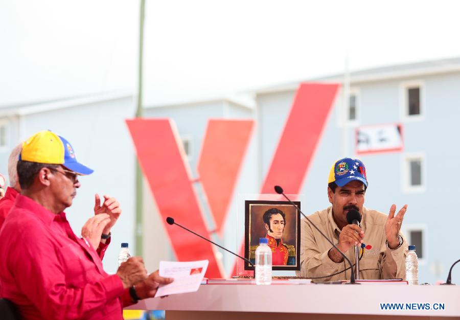 Image provided by Presidency of Venezuela, shows Venezuelan Acting President Nicolas Maduro (R), speaking during a delivery ceremony of houses built by the government for homeless people, in Playa Grande, in Vargas State, Venezuela, on March 14, 2013. (Xinhua/Presidency of Venezuela)