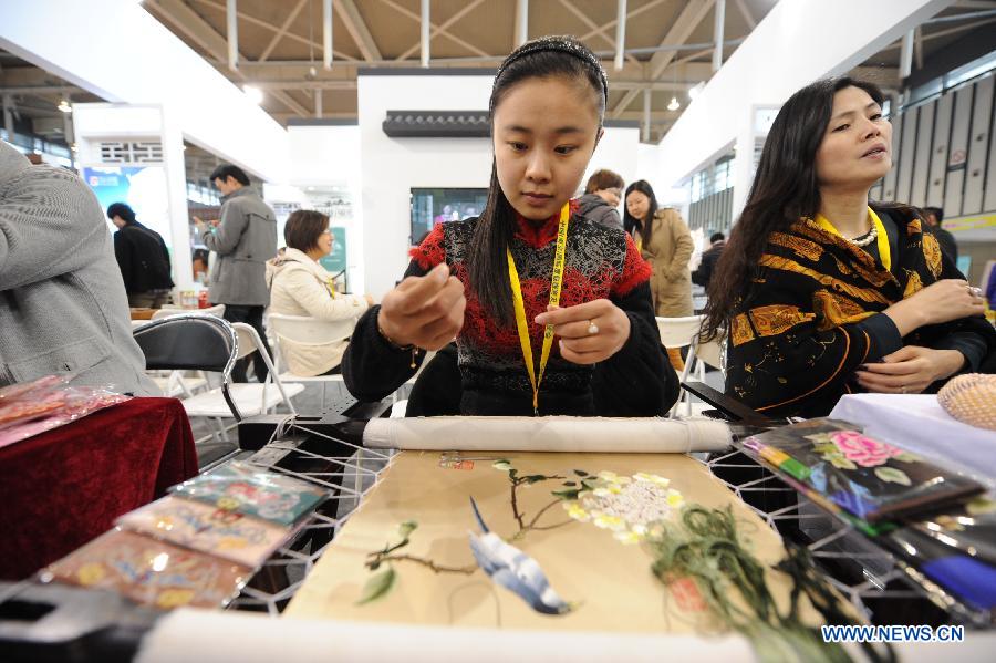 A girl demonstrates embroidery skills during the 2013 China International Exhibition for Caravanning, Motoring, Tourism (CMT China) in Nanjing, capital of east China's Jiangsu Province, March 15, 2013. The three-day exhibition, with the participation of 289 exhibitors from 28 countries and regions, opened in Nanjing Friday. (Xinhua/Shen Peng) 