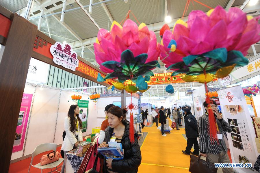 Visitors watch a display of folk tourism culture during the 2013 China International Exhibition for Caravanning, Motoring, Tourism (CMT China) in Nanjing, capital of east China's Jiangsu Province, March 15, 2013. The three-day exhibition, with the participation of 289 exhibitors from 28 countries and regions, opened in Nanjing Friday. (Xinhua/Shen Peng) 
