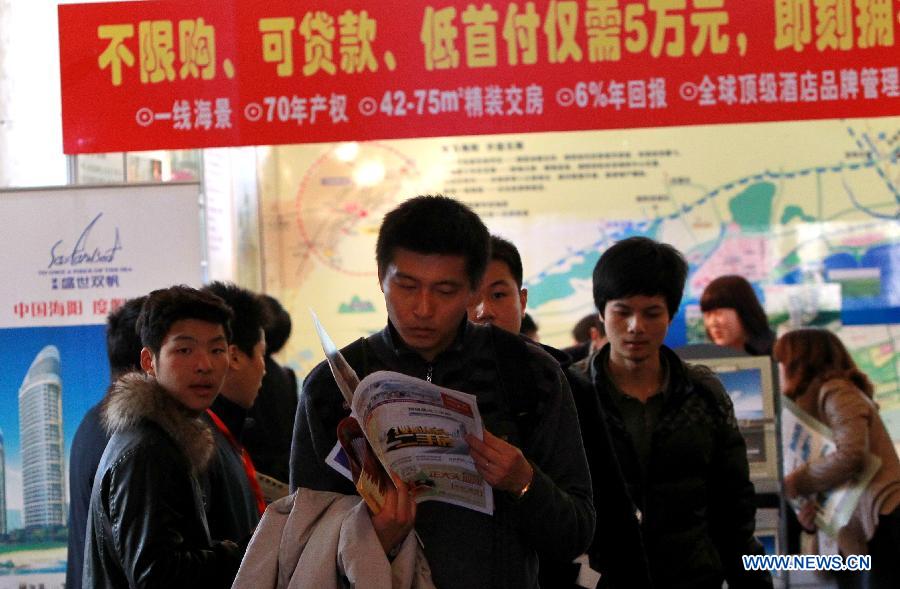 People read fly sheets at a real estate expo in east China's Shanghai Municipality, March 15, 2013. The expo lasts from March 15 to March 18. (Xinhua/Pei Xin)