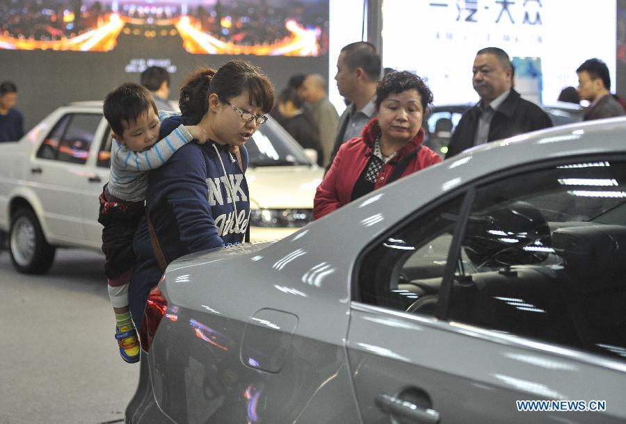 Local residents look at a car during a four-day automobile show in Urumqi, capital of northwest China's Xinjiang Uygur Autonomous Region, March 16, 2013. More than 1,000 types of vehicles from over 80 automakers were displayed at the show that kicked off on Friday. (Xinhua/Jiang Wenyao) 