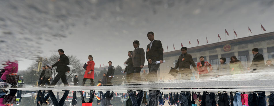 An upside-down photo shows the reflection of CPPCC members walking out of the Great Hall of People in Beijing, March 12, 2013. As one of two most important  political events held annually, CPPCC elected the new leadership this year. (Xinhua/Qin Qing) 