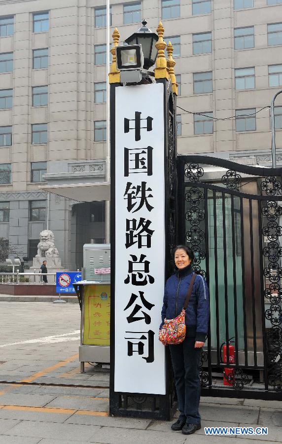 A woman poses with the name board of China Railway Corporation in Beijing, capital of China, March 17, 2013. The newly-founded China Railway Corporation hung out its name board on Sunday. (Xinhua/Chen Yehua) 