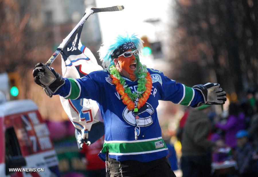 A hockey fan participates in the annual St. Patrick's Day Parade in Vancouver, Canada, March 17, 2013. Thousands of people have crowded downtown Vancouver to watch as bagpipers, Irish dancers and hurlers paraded with dreadlocked dancers, green samba queens, and even a roller derby team took part in the 9th annual St. Patrick's Day parade. The festivities continue the centuries-old custom of partying on the saint's feast day, March 17, to honour his role of helping convert the Irish to the Catholic faith. (Xinhua/Sergei Bachlakov)