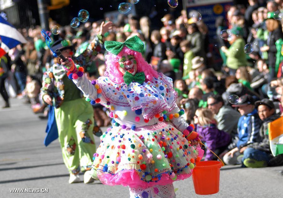 A clown entertains public during the annual St. Patrick's Day Parade in Vancouver, Canada, March 17, 2013. Thousands of people have crowded downtown Vancouver to watch as bagpipers, Irish dancers and hurlers paraded with dreadlocked dancers, green samba queens, and even a roller derby team took part in the 9th annual St. Patrick's Day parade. The festivities continue the centuries-old custom of partying on the saint's feast day, March 17, to honour his role of helping convert the Irish to the Catholic faith. (Xinhua/Sergei Bachlakov)