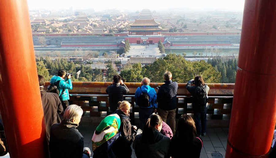 Tourists from China and abroad are enjoying a full view of the Forbidden City from the hilltop of Jing Hill Park. (Photo/Xinhua)