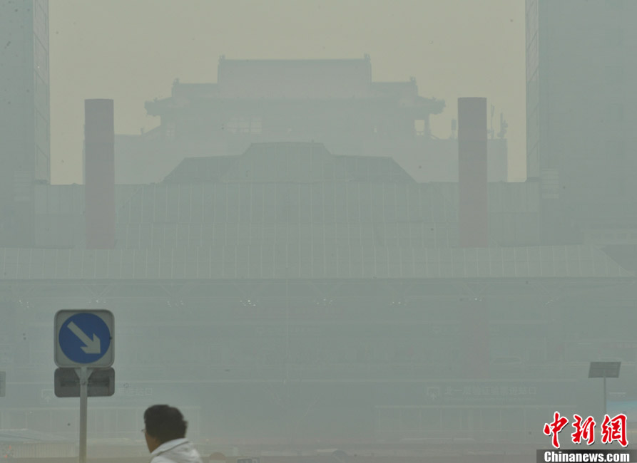 The fog-shrouded buildings are seen in Beijing, capital of China, March 17, 2013. Fog and smog blanketed Beijing on Sunday. (Photo/CNS)   