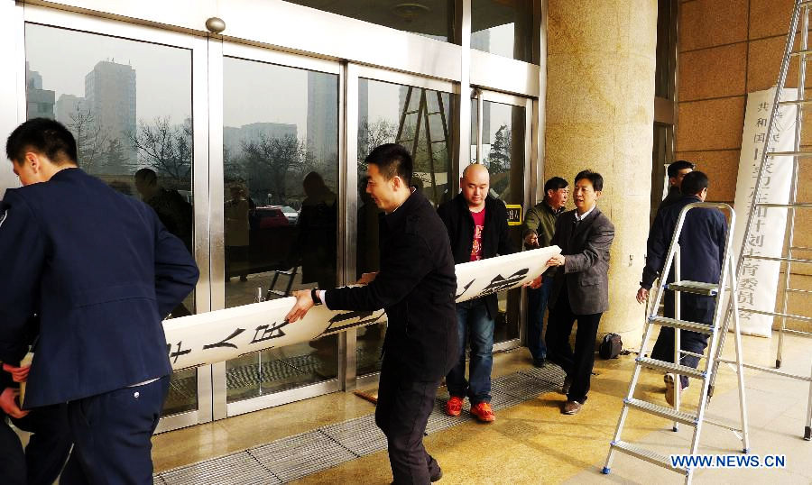 Workers remove the name plaque of the Ministry of Health in Beijing, capital of China, March 17, 2013. The newly-founded National Health and Family Planning Commission hung out its name plaque on Sunday morning, replacing the name plaque of the now-defunct Ministry of Health. (Xinhua/Lv Nuo)