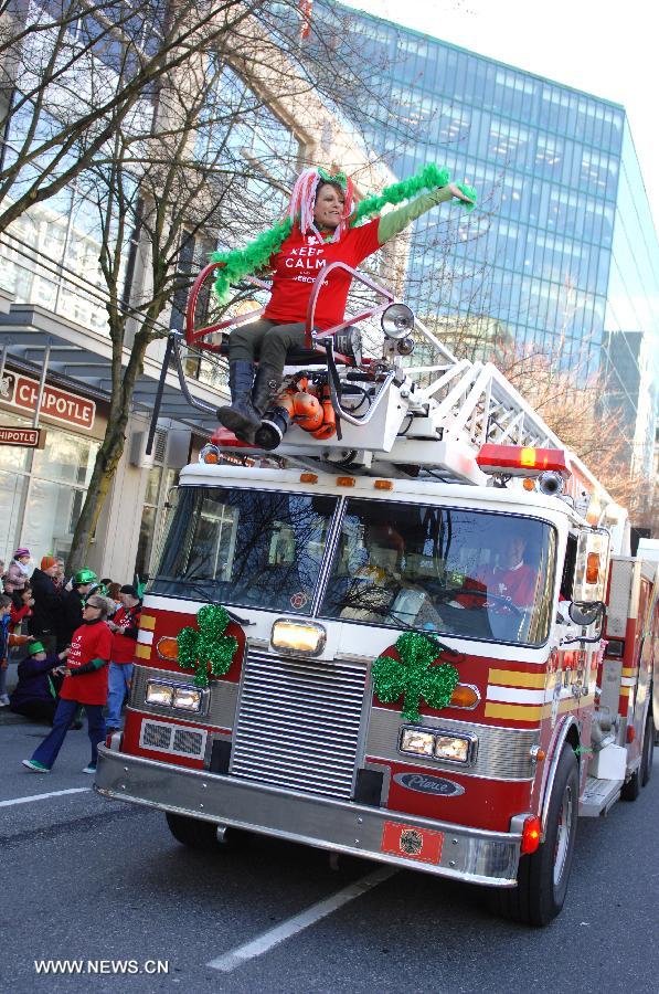  A bus drives during the annual St. Patrick's Day Parade in Vancouver, Canada, March 17, 2013. Thousands of people have crowded downtown Vancouver to watch as bagpipers, Irish dancers and hurlers paraded with dreadlocked dancers, green samba queens, and even a roller derby team took part in the 9th annual St. Patrick's Day parade. The festivities continue the centuries-old custom of partying on the saint's feast day, March 17, to honour his role of helping convert the Irish to the Catholic faith. (Xinhua/Sergei Bachlakov) 