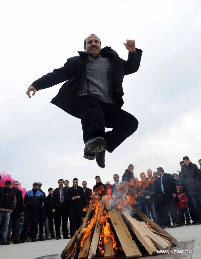A man jumps over a bunch of fire at Nevruz celebrations in Istanbul, Turkey, on March 17, 2013. The Nevruz performance, organized by the Joint Administration of Turkic Arts and Culture (TURKSOY), brings together more than 250 artists from different countries or regions to celebrate Nevruz in 15 cities of Turkey. (Xinhua/Ma Yan)