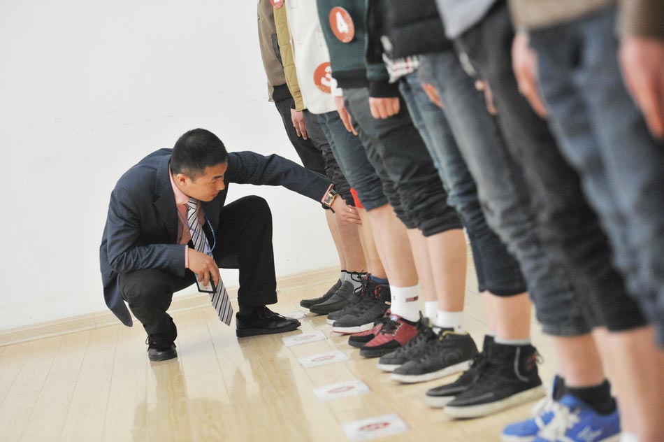 Candidate are in a test held to recruit flight security officers for Hainan Airlines, China's fourth largest airline, Taiyuan, northern China's Shanxi province on March 16, 2013. The airlines favored applicants who are graduates from military or police school or veterans. Besides appearance, applicants' manners, psychological quality in the interview, fighting skills and physical strength are also examined, which are essentials for flight security officers to deal with any emergent matter and security threat immediately.  (Photo/ Imagine China ) 