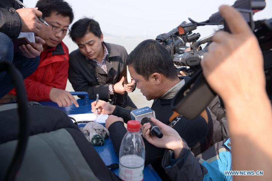 A frogman makes a description after a diving in the Laoyemiao water area of the Poyang Lake, east China's Jiangxi Province, March 18, 2013. Archaeologists discovered a sunk ship in the Laoyemiao area of the Poyang Lake, China's largest freshwater lake on Monday. The Laoyemiao area in the lake is often referred to as "China's Bermuda Triangle" because of the large number of boats that sank mysteriously in the area over the years. (Xinhua/Zhou Mi)