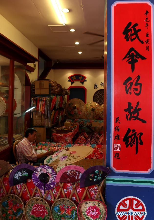 A man makes oil paper umbrellas at a shop in Yuanxiangyuan Village of Kaohsiung City in southeast China's Taiwan, March 18, 2013. The Yuanxiangyuan Village has attracted a good many tourists thanks to its burgeoning oil paper umbrella industry. (Xinhua/Xie Xiudong)