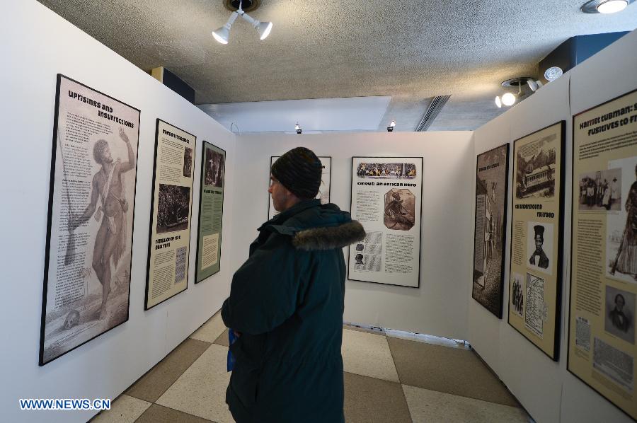 A man looks at illustrations on display during an exhibition commemorating the abolishment of slavery, at the United Nations (UN) headquarters in New York, on March 18, 2013. Beginning on Monday, the UN will be hosting a week of activities to highlight the significance of March 25, the International Day of Remembrance of the Victims and the Transatlantic Slave Trade. (Xinhua/Niu Xiaolei)