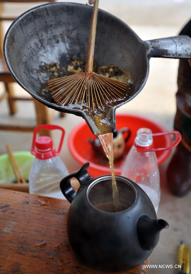 A competitor cooks youcha, a traditional local appetizer, in Guanyang County of Guilin, south China's Guangxi Zhuang Autonomous Region, March 19, 2013. A youcha cooking competition was held here on Tuesday to show the diet culture. (Xinhua/Lu Boan)