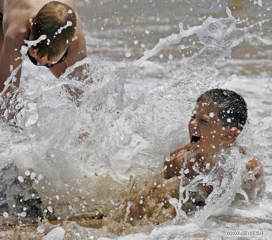 Two Russian boys play at the Beidaihe beach in Qinhuangdao, a coastal city of north China's Hebei Province, July 6, 2008. The China-Russia cooperation in tourism has substantially progressed, which also has promoted bilateral understandings and exchange of culture in recent years. The Year of Chinese Tourism in Russia in 2013 will be inaugurated by Chinese President Xi Jinping when he visits Moscow later this month. (Xinhua/Zhou Xuefeng)