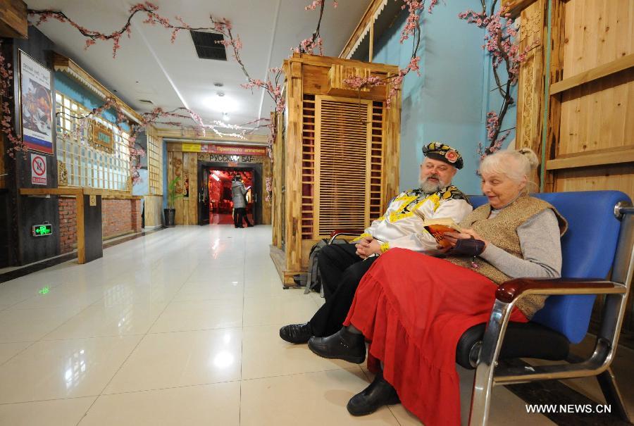 Eremin Sergei and his mother wait to watch performances at the Vasil Russian Street in Harbin, capital of northeast China's Heilongjiang Province, March 16, 2013. (Xinhua/Wang Jianwei) 