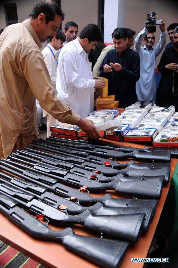 Policemen display seized weapons to media at a police station in northwest Pakistan's Peshawar on March 19, 2013. Police arrested two suspects who tried to smuggle weapons and ammunitions from Peshawar to Punjab province, local media reported. (Xinhua/Ahmad Sidique) 