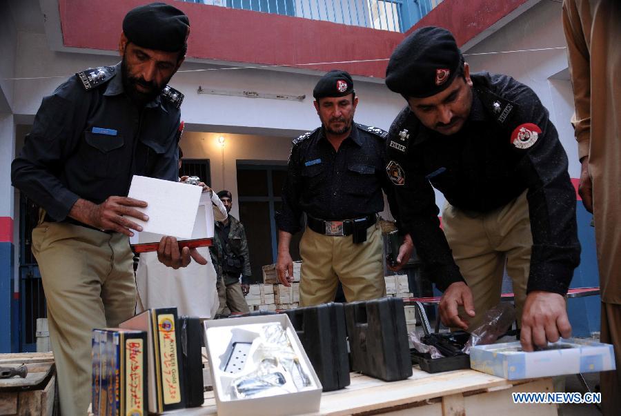 Policemen display seized weapons to media at a police station in northwest Pakistan's Peshawar on March 19, 2013. Police arrested two suspects who tried to smuggle weapons and ammunitions from Peshawar to Punjab province, local media reported. (Xinhua/Ahmad Sidique) 