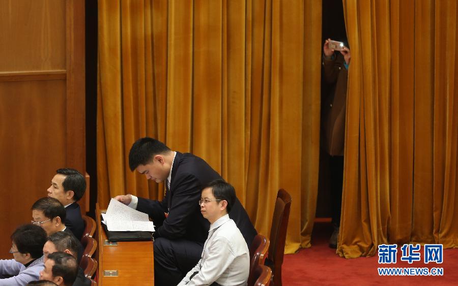 Photo shows a journalist taking photo through the curtains. In front of the camera was former NBA player Yao Ming who was listening to the meeting carefully. (Xinhua/ Jin Liwang)