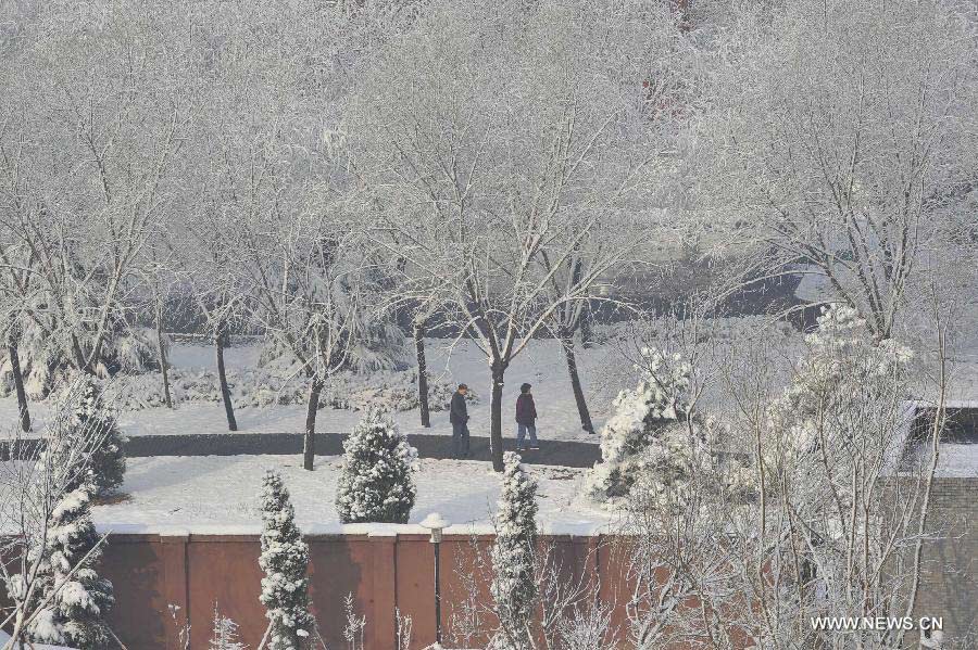 Two citizens walk in a residential area in the Shijingshan District of Beijing, capital of China, March 20, 2013. Beijing witnessed a snowfall with a depth reaching 10-17 centimeters overnight. The snowfall happened to hit the city on the Chinese traditional calendar date of Chunfen, which heralds the beginning of the spring season. Chunfen, which literally means Spring Equinox or Vernal Equinox, falls on the day when the sun is exactly at the celestial latitude of zero degrees. (Xinhua/Lu Peng)